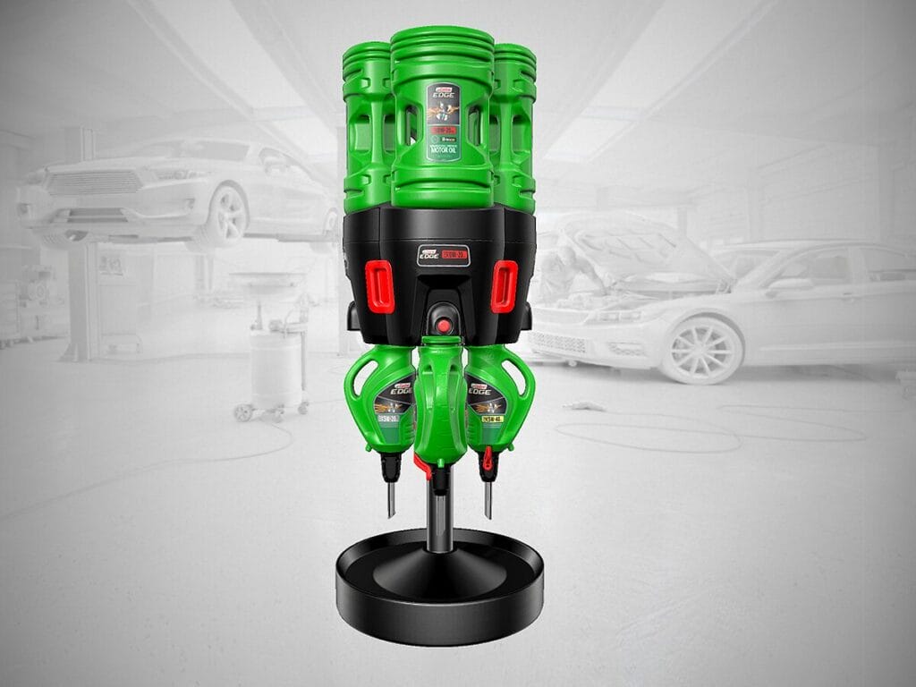 A Castrol Edge motor oil dispensing unit with green bottles mounted on a stand, displayed against a blurred automotive repair shop background with vehicles on lifts.