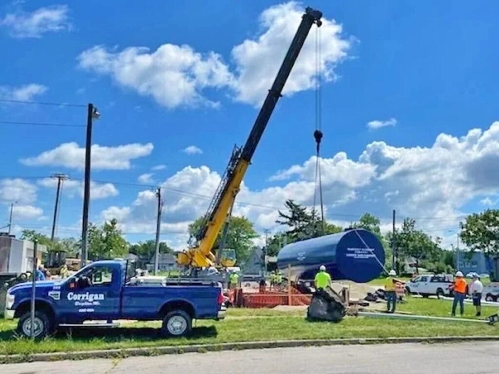 Crane installing commercial fuel storage tank for gas station brand conversion