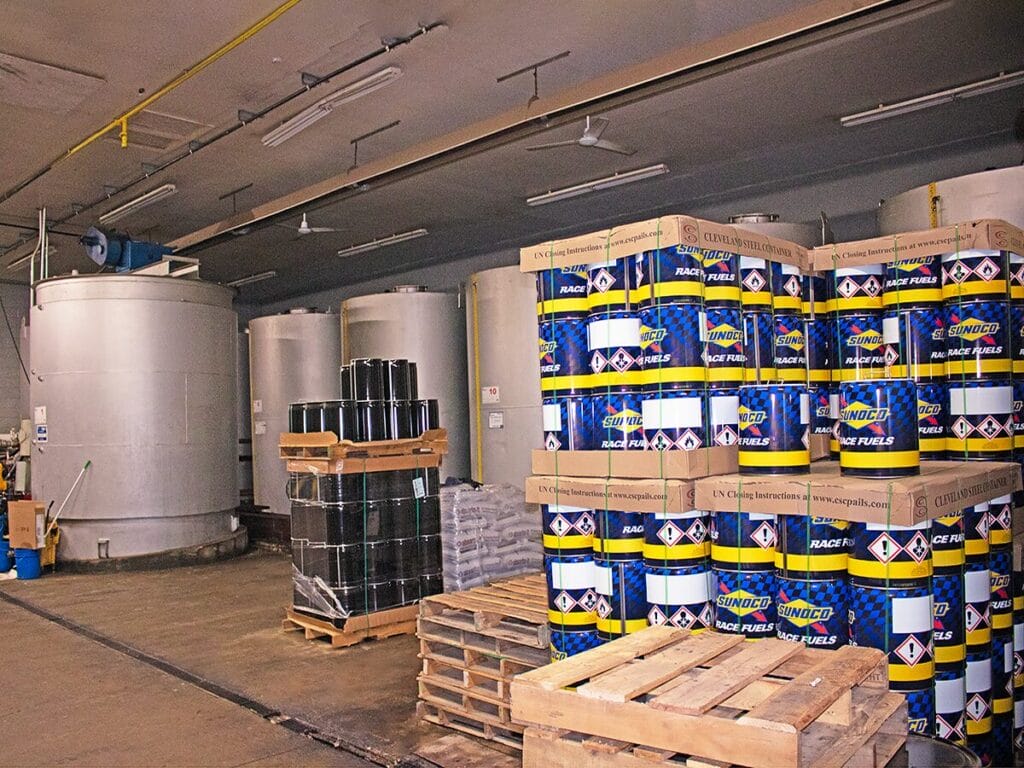 Bulk race fuel storage tanks and Sunoco race fuel drums in warehouse
